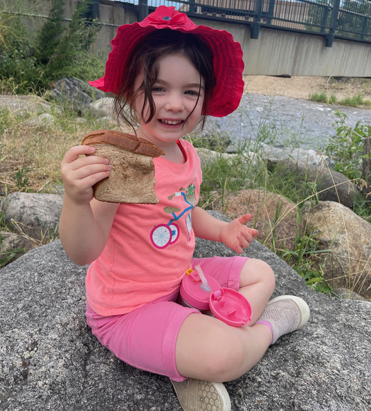Evie eating a peanut butter & jelly sandwich at Estes Park, CO